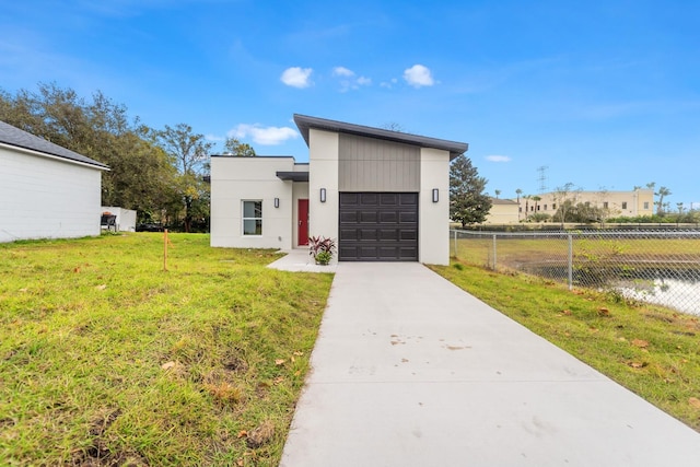 contemporary home featuring a garage and a front lawn