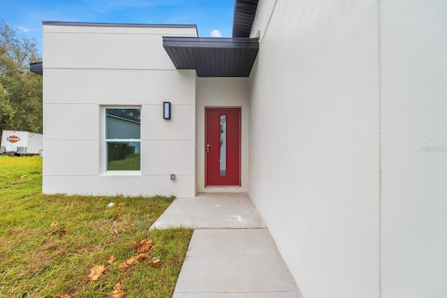 view of exterior entry featuring a yard