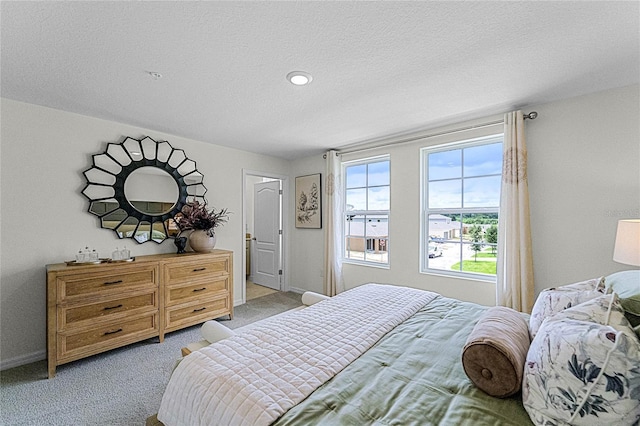 bedroom featuring light colored carpet and a textured ceiling