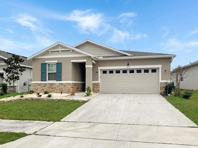 craftsman-style home featuring an attached garage, stone siding, concrete driveway, and a front yard