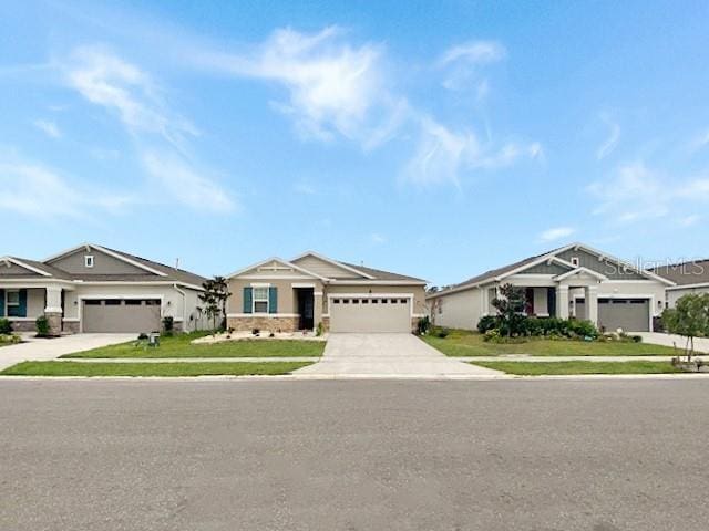 view of front of home featuring a garage, a residential view, concrete driveway, and a front yard