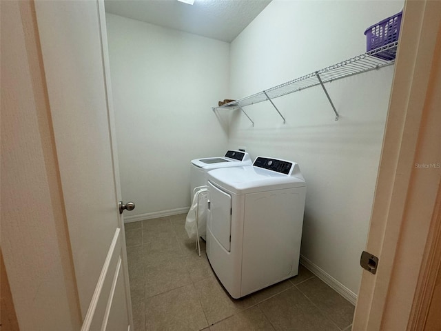 laundry room with washer and dryer and light tile patterned floors