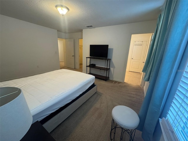 bedroom with carpet floors and a textured ceiling