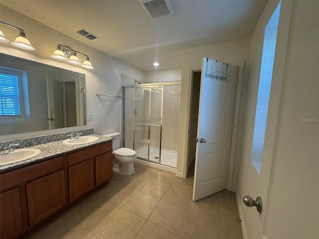 bathroom with vanity, tile patterned floors, a shower with door, and toilet