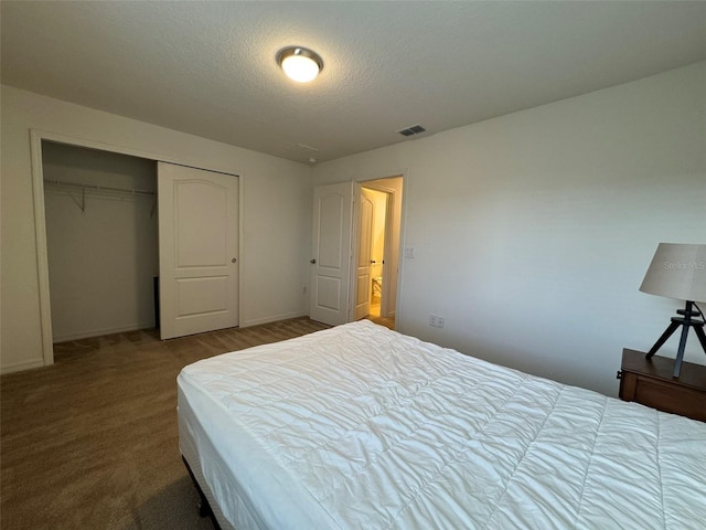 bedroom with a closet, a textured ceiling, and carpet flooring