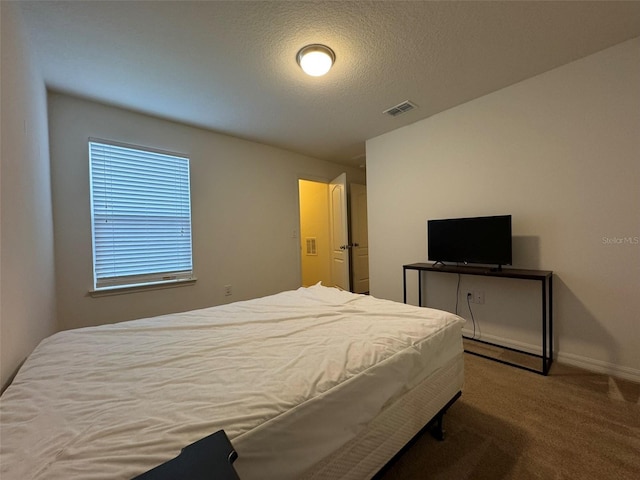 carpeted bedroom featuring a textured ceiling