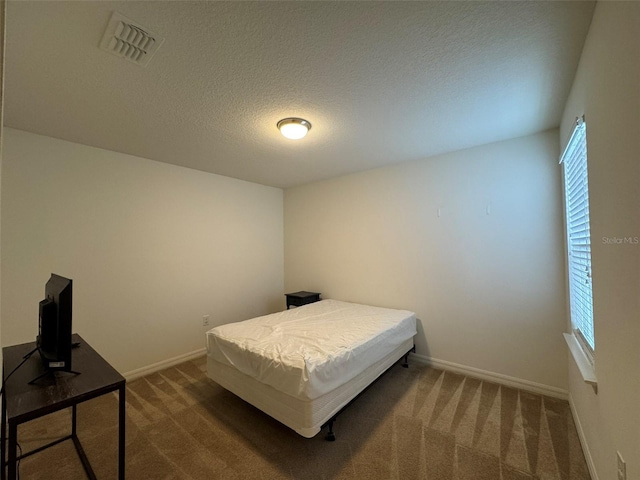 carpeted bedroom with a textured ceiling