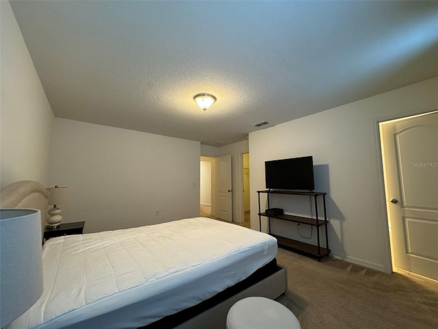 carpeted bedroom featuring a textured ceiling