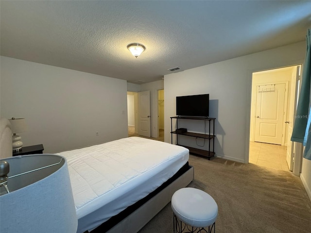 bedroom featuring light carpet and a textured ceiling