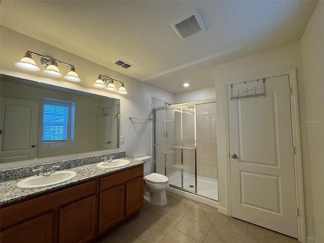 bathroom featuring vanity, a shower with shower door, tile patterned floors, and toilet