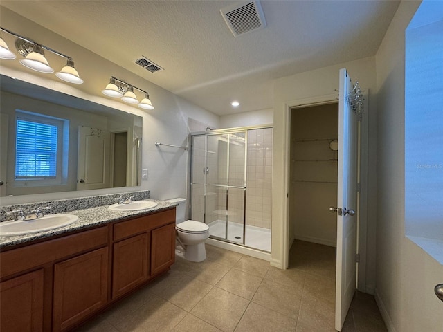 bathroom with vanity, an enclosed shower, toilet, tile patterned floors, and a textured ceiling