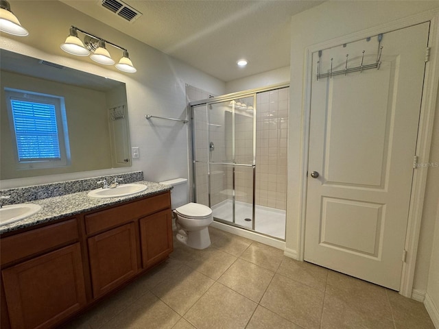 bathroom featuring walk in shower, tile patterned floors, vanity, and toilet