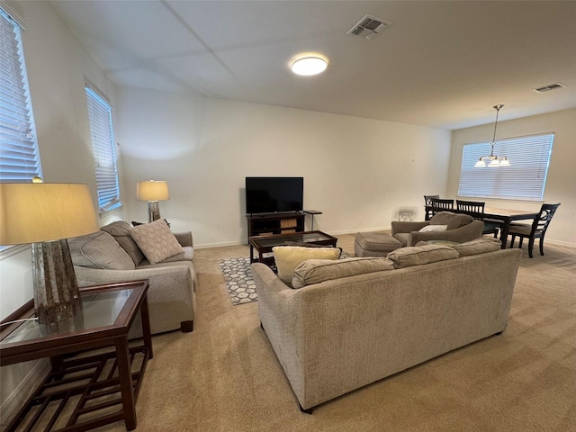 carpeted living room featuring a chandelier