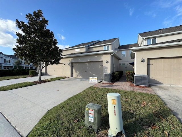 view of front of house featuring a garage and central air condition unit