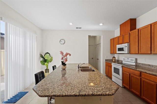 13731 Bravante Aly, Windermere, FL 34786 - kitchen featuring white appliances, a sink, light tile patterned floors, recessed lighting, and a breakfast bar