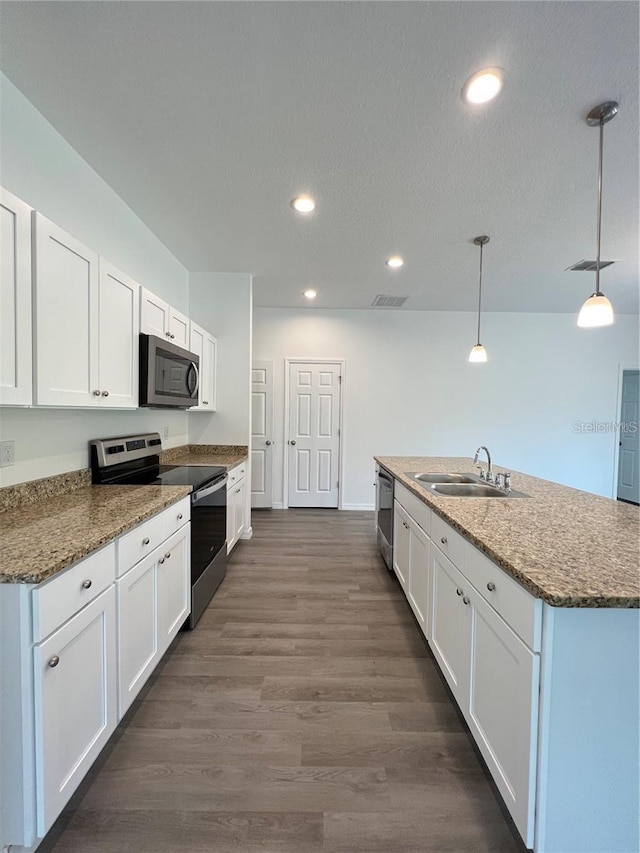 kitchen with pendant lighting, sink, dark wood-type flooring, appliances with stainless steel finishes, and white cabinets