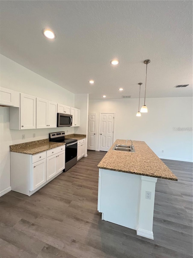 kitchen with decorative light fixtures, a center island with sink, sink, white cabinetry, and stainless steel appliances