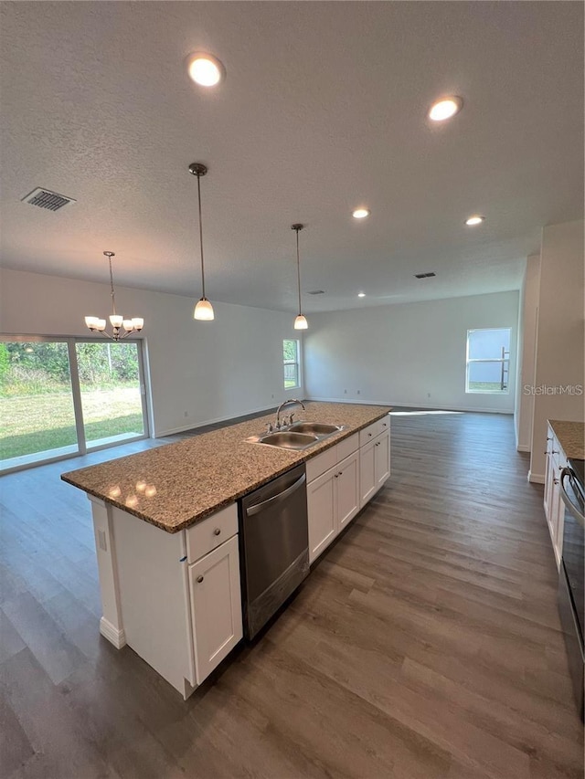 kitchen with pendant lighting, white cabinets, dishwasher, sink, and a kitchen island with sink