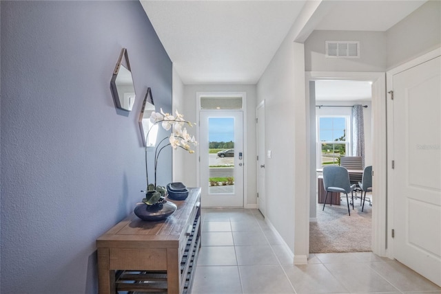 doorway to outside with light tile patterned floors