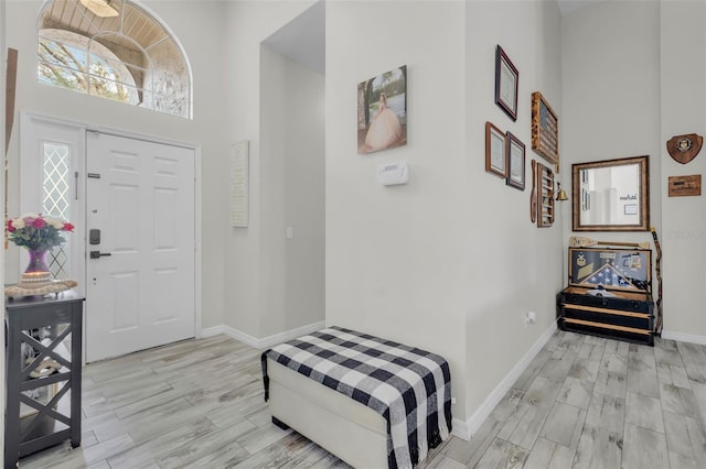 entrance foyer featuring a towering ceiling and light hardwood / wood-style flooring