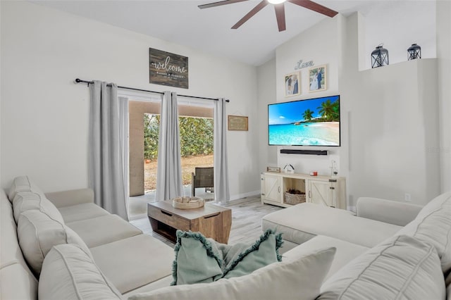 living room with light hardwood / wood-style floors, lofted ceiling, and ceiling fan