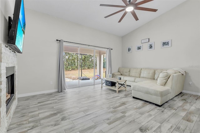 living room with ceiling fan, a fireplace, and high vaulted ceiling