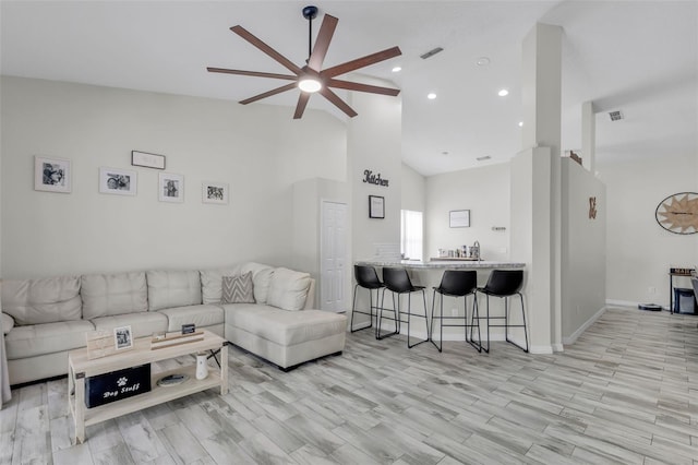 living room featuring light wood-type flooring, ceiling fan, and high vaulted ceiling