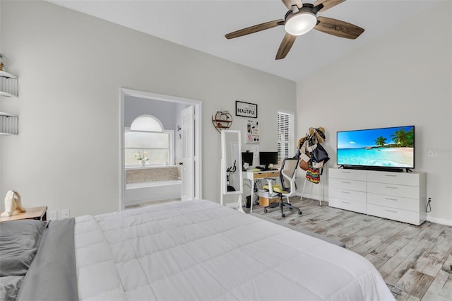 bedroom featuring ceiling fan, light wood-type flooring, connected bathroom, and lofted ceiling