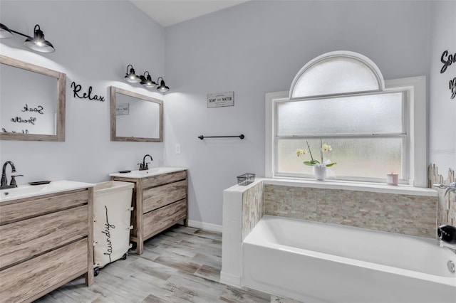 bathroom featuring vanity, wood-type flooring, and a bathing tub