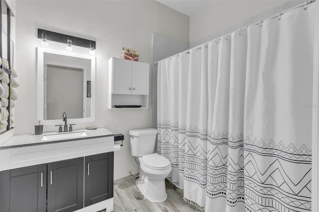 bathroom featuring wood-type flooring, toilet, and vanity