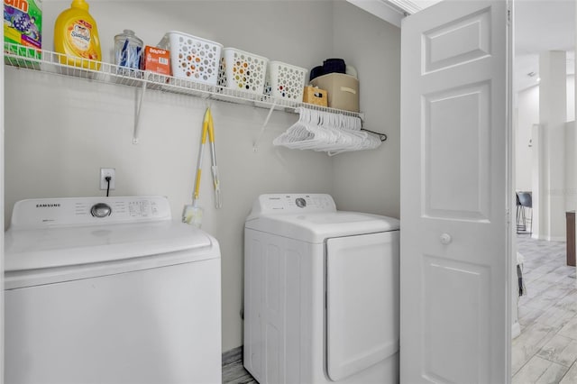 washroom with light hardwood / wood-style floors and washing machine and dryer