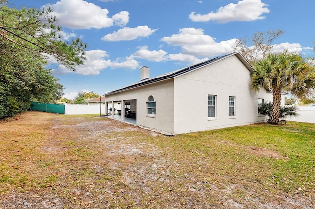 view of home's exterior with a lawn and a patio area