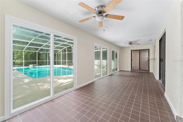 unfurnished sunroom featuring ceiling fan and a wealth of natural light