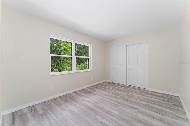 unfurnished bedroom with light hardwood / wood-style floors and a closet