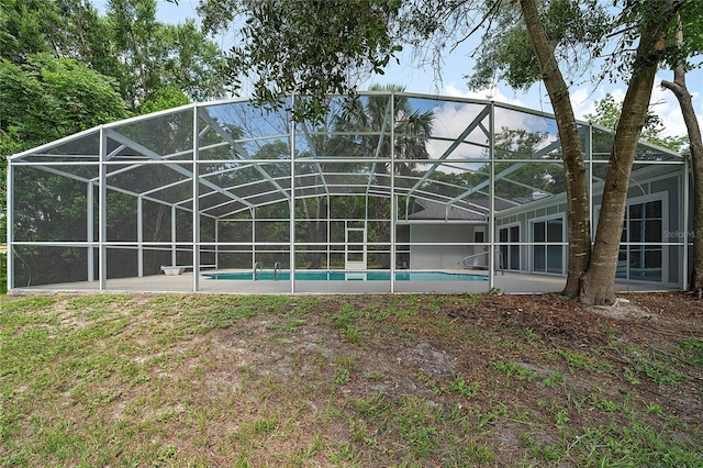 view of swimming pool with glass enclosure and a patio area