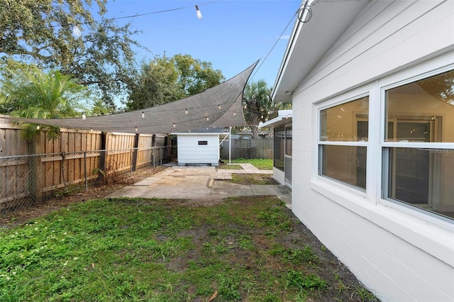 view of yard featuring a shed and a patio area