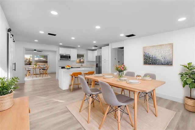 dining room featuring baseboards, light wood-style flooring, visible vents, and recessed lighting