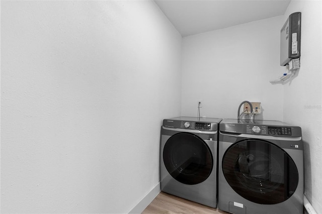 laundry room featuring light wood-type flooring, baseboards, independent washer and dryer, and laundry area