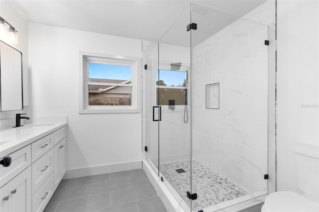 full bath with tile patterned floors, double vanity, toilet, a marble finish shower, and a sink