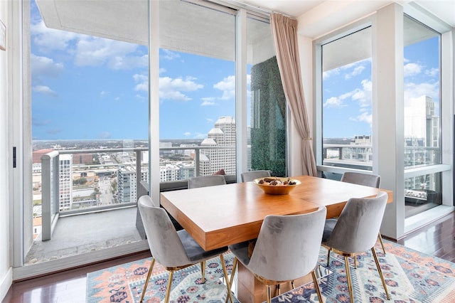 dining space featuring hardwood / wood-style floors, a healthy amount of sunlight, and floor to ceiling windows