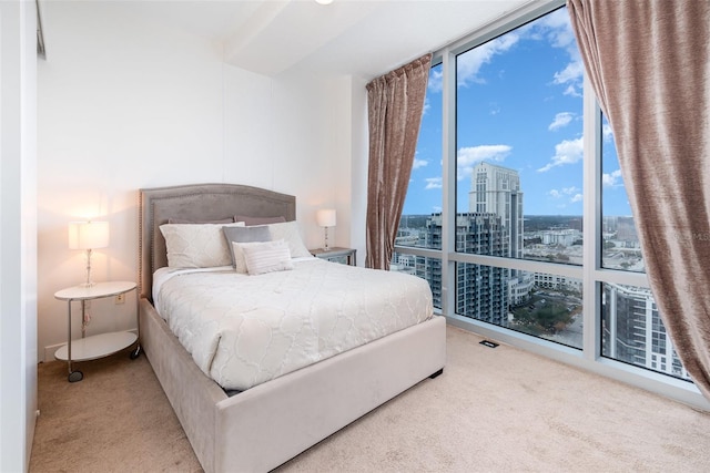 bedroom featuring a wall of windows and carpet floors