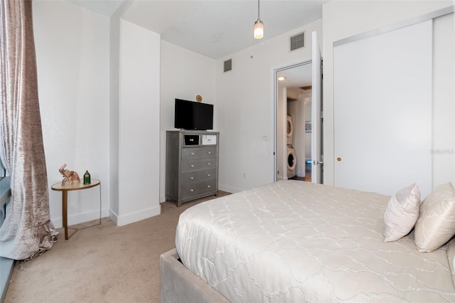 carpeted bedroom featuring washer / dryer