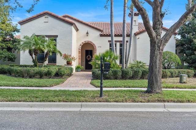 mediterranean / spanish-style home featuring a front yard