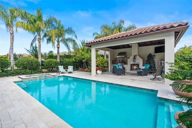 view of pool with an outdoor fireplace, a patio area, and a gazebo