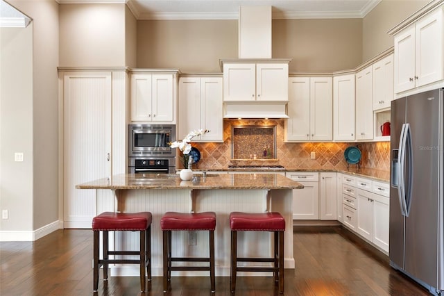 kitchen with stainless steel appliances, light stone counters, and a center island