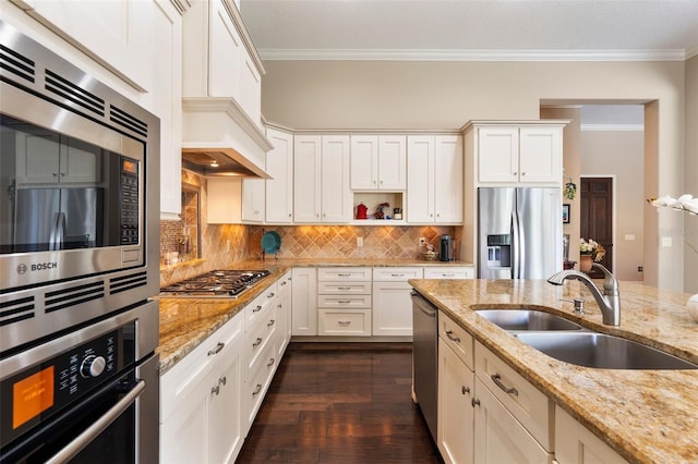 kitchen featuring stainless steel appliances, tasteful backsplash, light stone countertops, ornamental molding, and sink