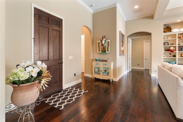 foyer entrance with crown molding and dark hardwood / wood-style floors