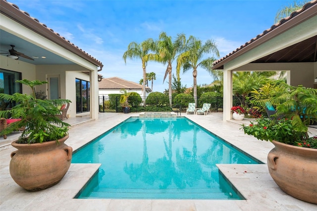 view of swimming pool featuring ceiling fan, an in ground hot tub, and a patio