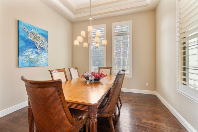 dining area featuring a tray ceiling, dark hardwood / wood-style flooring, and a notable chandelier