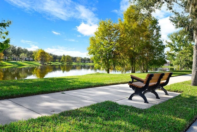 surrounding community featuring a water view and a lawn